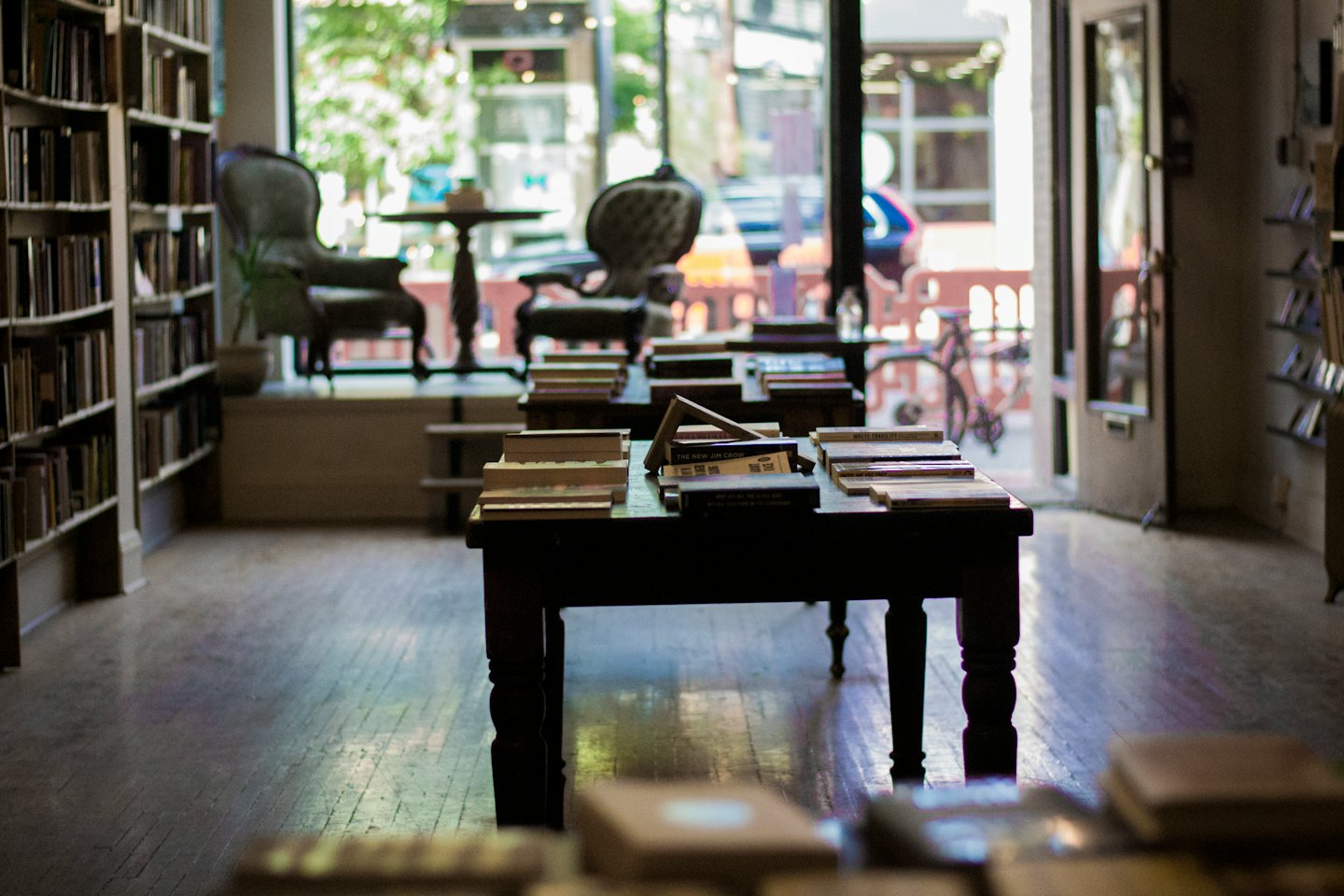 Dark wooden bookshelves and tables filled with books in a bookstore.