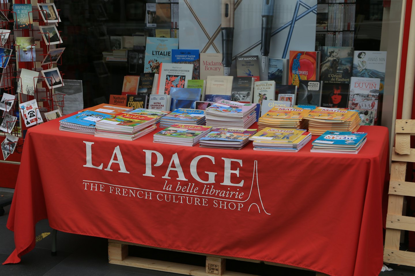 Outdoor bookshop display with a red table of maths books.