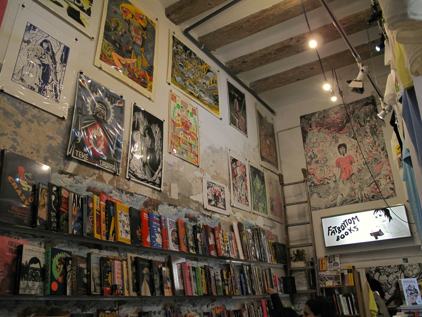 Books and posters fill the shelves of an independent bookstore.