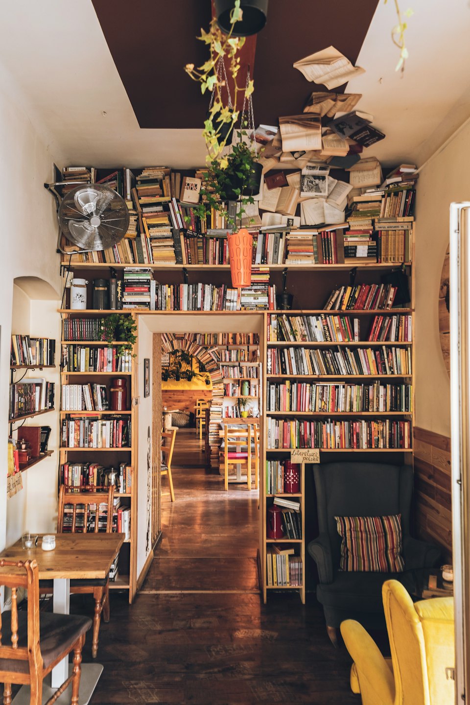 Wooden bookshelves line the walls of a cozy cafe.